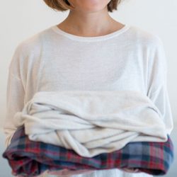 woman holding folded clothes